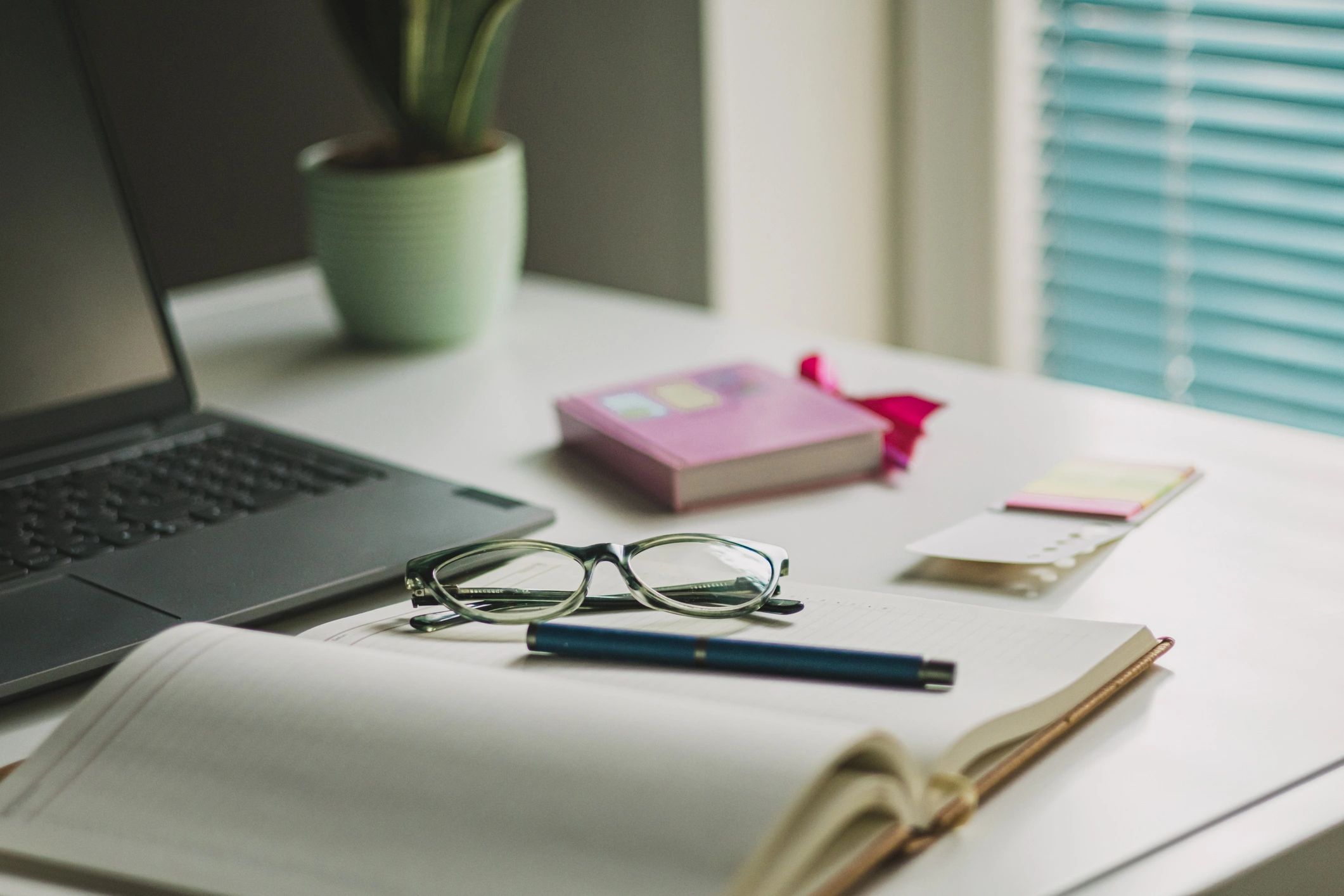 Writer's desk with laptop, coffee, and reading glasses