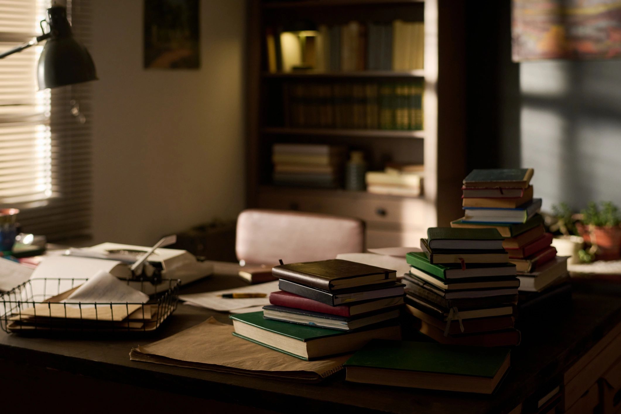 Books arranged on a desk in a sunlit workspace